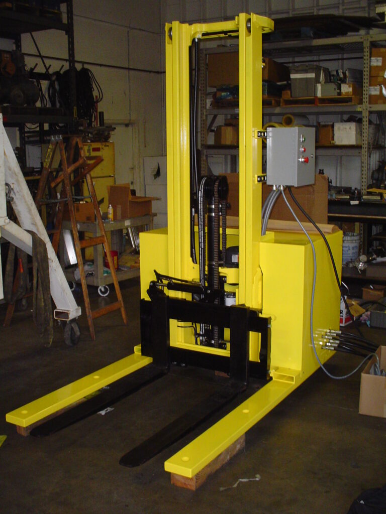 Yellow pallet stacker with forks and a control box in a shop