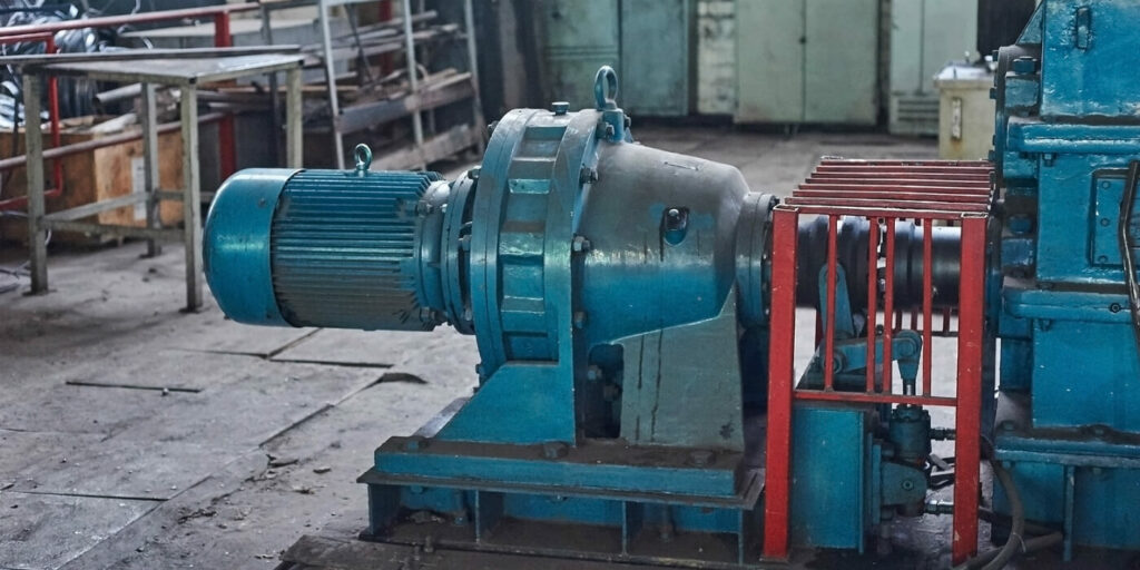 Electric motor and gear reducer on a steel base in a factory