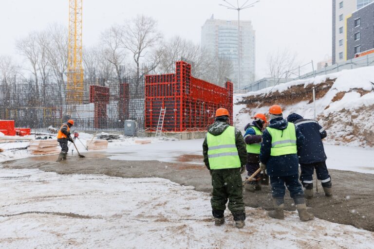 Construction workers in the snow. Working through inclement weather requires custom construction solutions, something Mathew's Mechanical specializes in.